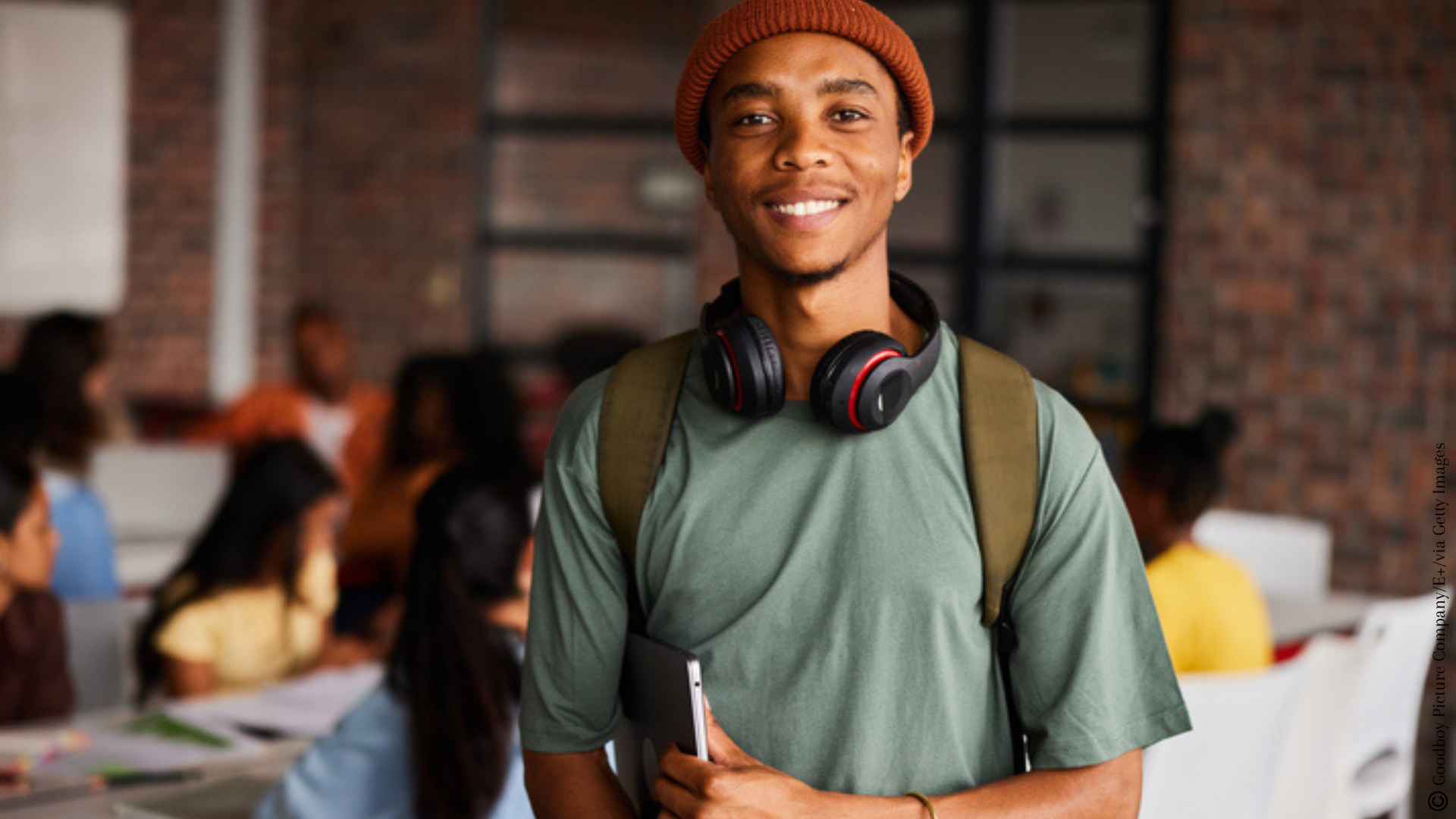 Un étudiant dans sa salle de classe avec ses camarades en arrière plan. 