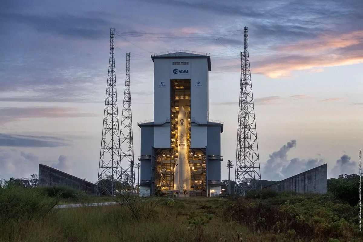 Prise de vue du lanceur Ariane 6 à la tombée de la nuit sur son pas de tir, sous la protection du portique mobile.